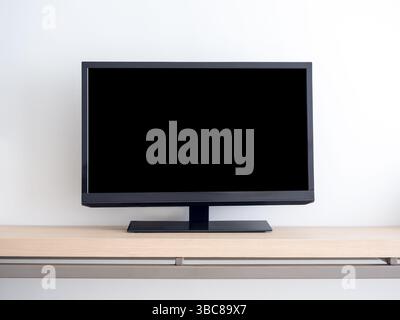 Vorderansicht des leerstehenden Mockup-Raumes auf schwarzem Smart-TV mit dunklem leerem Holzregal, isoliert auf weißem Wandhintergrund im Hotelzimmer Stockfoto