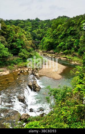 Der Keelung River schlängelt sich durch die üppige grüne Landschaft von Shifen, Taiwan, und schlängelt sich seinen Weg um Felsbrocken und kleine Wasserfälle. Umgeben von dichten subtropischen Wäldern bietet der Fluss einen friedlichen natürlichen Rückzugsort im malerischen Pingxi District Stockfoto