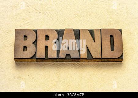 Markenwort in Vintage Letterpress Holzart gegen strukturierten Rindenpapierhintergrund Stockfoto