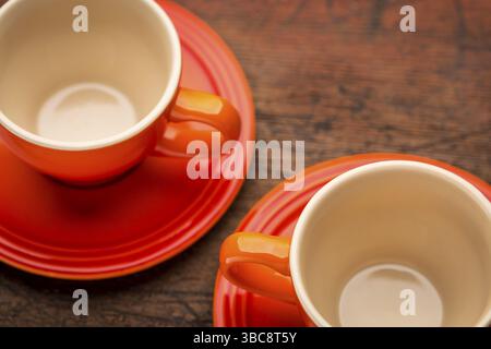 Zwei leere Steingut-Kaffeetassen auf dem Holztisch, geringe Tiefe der Feile Stockfoto