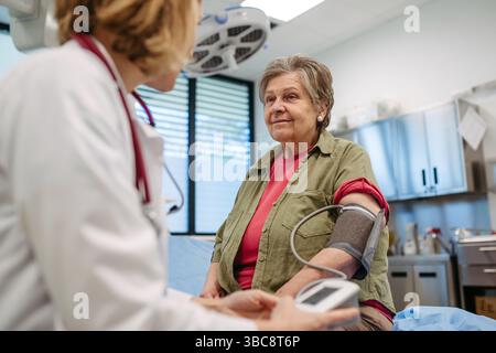 Ältere Frau, die den Blutdruck kontrolliert hat, vorbeugende Versorgung. Stockfoto
