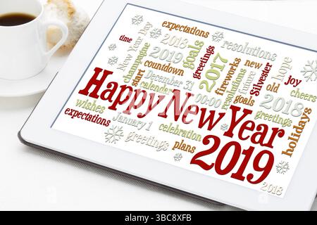 Grußkarte „Happy New Year 2019“ – Wortwolke auf einem digitalen Tablet mit einer Tasse Kaffee Stockfoto
