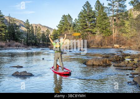 Aufblasbares Stand Up Paddleboard auf einem Bergfluss - Poudre River in Colorado in Frühlingslandschaft mit niedrigem Wasserfluss Stockfoto