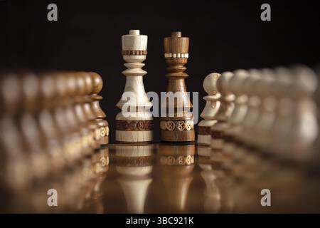 Schach auf dunklem Hintergrund. Ein Puzzlespiel mit kniffligen Kombinationen, die Planung und Denken erfordern Stockfoto