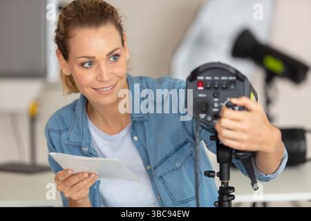 Der Fotograf passt das Blitzlicht im Studio an Stockfoto