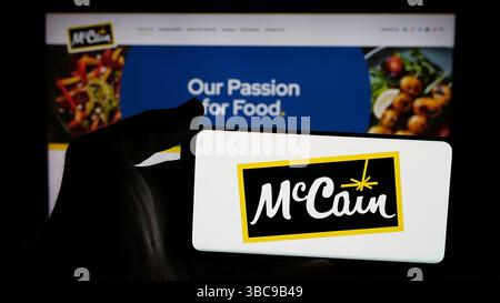 Auf dieser Abbildung befindet sich ein Mobiltelefon mit dem Logo des kanadischen Lebensmittelunternehmens McCain Foods Limited auf dem Bildschirm vor der Webseite. Stockfoto