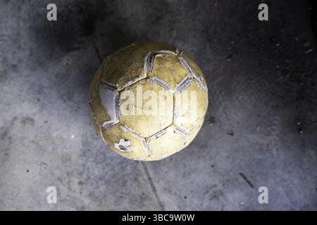Der alte Fußball liegt auf der Straße, Sport und Sport Stockfoto