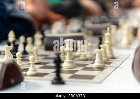 Schachbrett im Freien mit Kunststoffteilen. Öffentlicher Bereich. Schließen Sie große Stücke und Schachbrett von Straßenschach im Park. Ein riesiges Sammelspiel Stockfoto