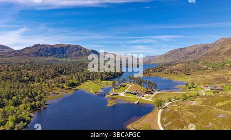 Glen Affric Cannich, Schottland, blauer Himmel und Loch mit Bäumen an einem sonnigen Frühlingstag Stockfoto