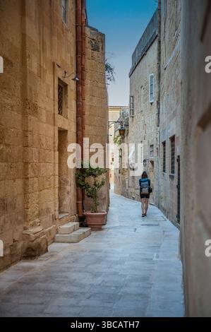 Wunderschöner Blick auf die alte, enge mittelalterliche Straßenstadt Mdina, Malta. Touristen laufen die Straße hinunter. Stockfoto