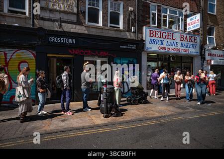 Brick Lane Beigel Bake Brick Lane East London England UK Mai 2025 Ein Beigel (Brick Lane Schreibweise) oder Bagel ist ein traditionelles jüdisches Brot, eine Variante eines Bagel, und ist besonders bekannt für seine Verbindung zum East End von London, insbesondere Brick Lane. Der Begriff „beigel“ leitet sich vom jiddischen Wort „Beygal“ ab. Beigels sind in der Regel kleiner und dichter als amerikanische Bagels und werden vor dem Backen oft in Wasser gekocht. Wiki unten: Ein Bagel (jiddisch בײגל, romanisiert: Beygl; Polnisch bajgiel [ˈbajɡʲɛl]; auch beigel) ist ein Brötchen aus den jüdischen Gemeinden Polens Stockfoto