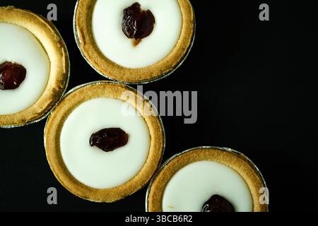 London UK, 19. Mai 2025, authentische traditionelle Bakewell Tarts Fondant-Zuckerglasur und Mandel- und Respberry-Füllung Stockfoto