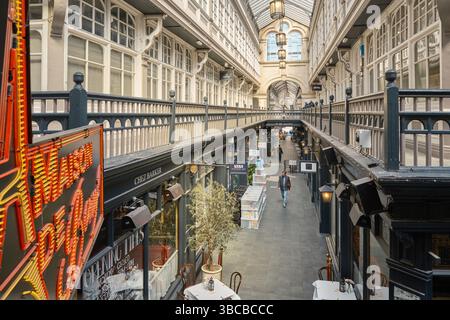 Innenansicht der Castle Arcade in Cardiff, Wales, mit viktorianischer Architektur, Boutiquen, Cafés, und ein überdachtes Glasdach mit Tageslicht Stockfoto