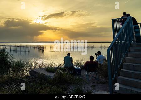 Fotografen machen atemberaubende Sonnenuntergänge über das ruhige Wasser des Naturparks albufera, einer wunderschönen Lagune in der Nähe von valencia, spanien Stockfoto