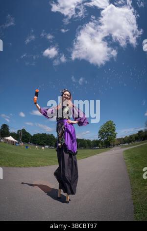 Eine junge Dame auf Stelzen schießt beim Piratenfestival in New Paltz, New York, kleine Blasen aus ihrer Wasserpistole. Stockfoto