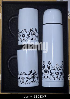 Weißes Kaffeebecher-Set mit Thermoskanne in Geschenkbox Stockfoto