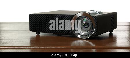 Moderner Videoprojektor auf Holztisch vor weißem Hintergrund Stockfoto