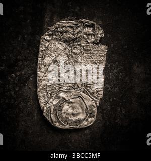 Die Nahaufnahme einer rostigen Dose vor dunklem Hintergrund unterstreicht die Textur und den Verschleiß des Metalls. Stockfoto