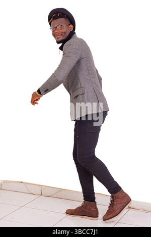 Hübscher junger Geschäftsmann mit elegantem Anzug und schwarzem Hut, der Kopf geht. Stockfoto