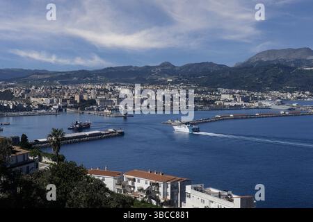 Weite Küstenlandschaft mit Ceuta, Hafeninfrastruktur und bergigem Gelände dahinter. Stockfoto