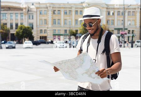 afroamerikaner, der Karte hält und sie ansieht Stockfoto