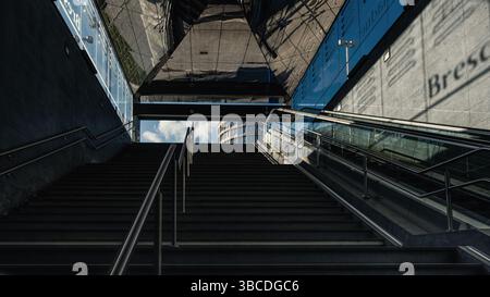 Wenn man die Treppe zur U-Bahn-Station Bresciadue in Brescia, Italien, hinaufblickt, kann man die Skyline der Stadt und den hellen Himmel darüber sehen. Stockfoto