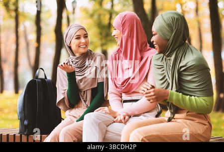 Drei Muslimische Arabische Frauen Sprechen Auf Der Bank Im Park Sitzen Stockfoto