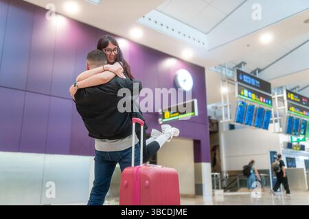 Glückliche Touristen, die sich nach der Ankunft am Flughafen umarmen Stockfoto