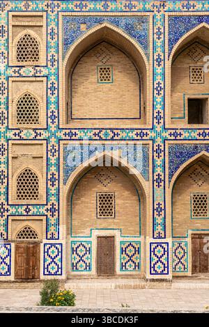 Die farbenfrohe Fassade der Ulugbek Madrasah in Buchara, Usbekistan, ist mit geometrischen Fliesen und Bogenfenstern im Timurid-Stil dekoriert. Stockfoto