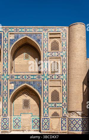 Ein Blick aus der Nähe von geometrischen Fliesen und Kalligrafie ziert Ulugbek Madrasah in Buchara, Usbekistan, ein Meisterwerk des Timuriden-Designs. Stockfoto