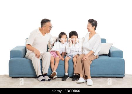Vier Generationen (Großeltern und Enkel) auf dem Sofa telefonieren Stockfoto