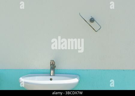 Ein Hintergrund die grobe Struktur einer alten zweifarbigen Putzwand mit Handwaschhähnen Stockfoto