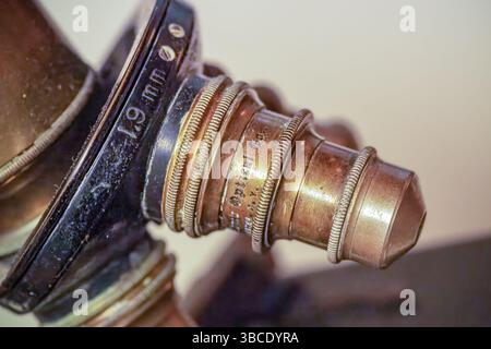 Nahaufnahme einer Vintage-optischen Linse mit 19-mm-Markierung mit graviertem Text und strukturierten Messingbeschlägen, Teil eines historischen wissenschaftlichen Instruments. Stockfoto