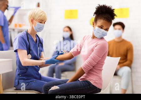 Arzt Impfen Schwarz Teen Mädchen Gegen Coronavirus Sitzt Im Krankenhaus Stockfoto