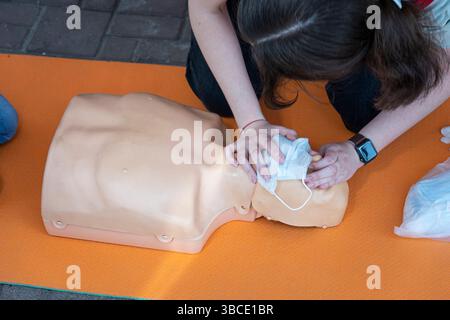 Frau, die HLW an einer Schaufensterpuppe zum Training durchführt. Direkte Herzmassage. Erste-Hilfe-Training an einer medizinischen Dummy. Stockfoto