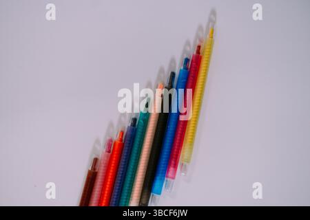 Farbige Buntstifte auf einer sauberen, weißen Oberfläche. Ein einfaches, lebendiges Bild, das sich für kreative oder pädagogische Themen eignet. Back-to-School-Konzept Stockfoto