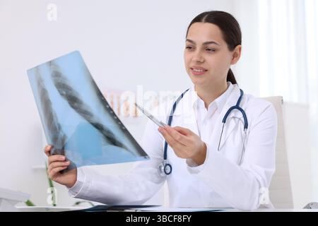 Arzt untersucht MRT-Scan am Schreibtisch im Krankenhaus Stockfoto