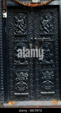 Eine handgeschnitzte Holztür mit komplizierten Details. Foto in der Altstadt von Bhaktapur, Nepal. Stockfoto