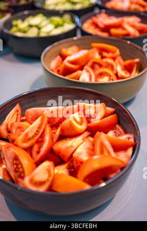 Frisch geschnittene Tomaten in Schüsseln bei einem Catering-Event, Bio-Pflaumentomaten für eine Salatbar Stockfoto