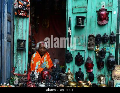 Eine ältere nepalesische Frau, die Artefakte in einem Laden am Durbar Square in Patan, Nepal, verkauft. Stockfoto
