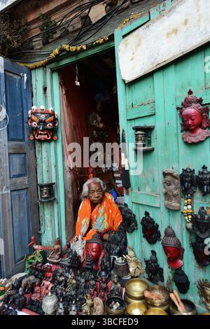 Eine ältere nepalesische Frau, die Artefakte in einem Laden am Durbar Square in Patan, Nepal, verkauft. Stockfoto