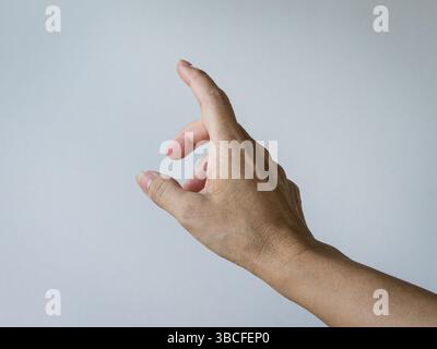 Die weibliche Hand bildet eine zeigende Geste. Vor weißem Hintergrund. Stockfoto