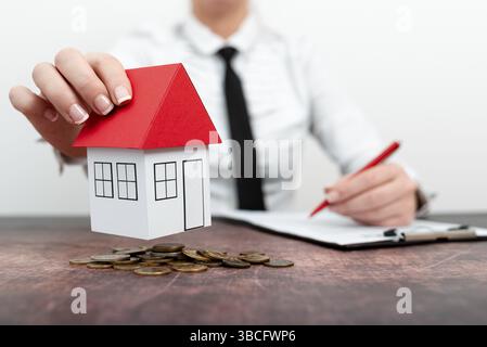 Immobilienmakler und Kunde schütteln sich die Hände nach dem Abschluss des Vertrags nach der Hausversicherung und dem Investitionsdarlehen. Hausmodell mit Immobilienmaklern Stockfoto