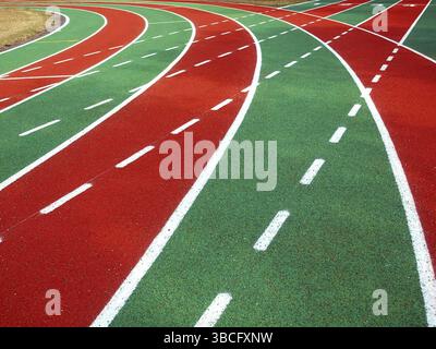 Eine Laufbahn in einem Stadion mit Markierungen in weiß, rot und grün und solide und gestrichelte Linien Stockfoto