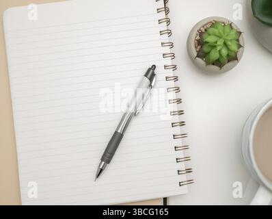 Topf mit Pflanze und Becher auf dem Schreibtisch. Iinfrormation auf Papier geschrieben Stockfoto