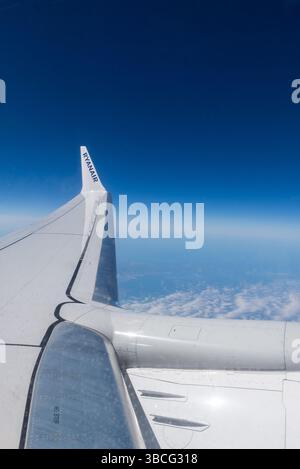 Der Flügel einer Ryanair Boeing 737 MAX 8200 fliegt in großer Höhe über Frankreich, mit tiefblauem Himmel. Ryanair-Titel auf Flügelspitze Winglet Stockfoto