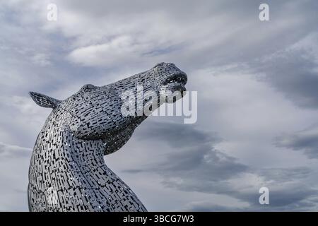 Falkirk, Vereinigtes Königreich - 20. Juni 2022: Eine der Kelpies-Pferdekopfskulpturen mit einem ausdrucksstarken, langbelichteten Himmel dahinter Stockfoto