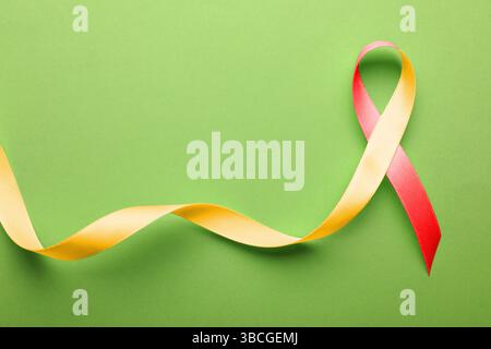 World Hepatitis Day. Gelb-rotes Farbband auf hellgrünem Hintergrund, Draufsicht. Leerzeichen für Text Stockfoto