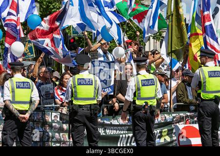 London, Großbritannien. Mai 2025. Pro-Israel-Anhänger halten pro-Israel-Zeichen hoch, während Pro-palästinensische Anhänger während des Nakba-marsches vor ihnen vorbeiziehen. Stockfoto