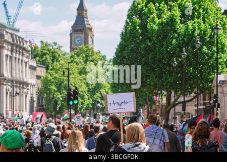 London, Großbritannien. Mai 2025. Pro-palästinensische Unterstützer, die Plakate tragen und palästinensische Fahnen schwenken, nehmen an der Nakba-Marsch 77 durch London Teil Stockfoto